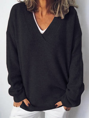 Black ribbed knit V-neck sweater with a relaxed fit, worn over a white top.