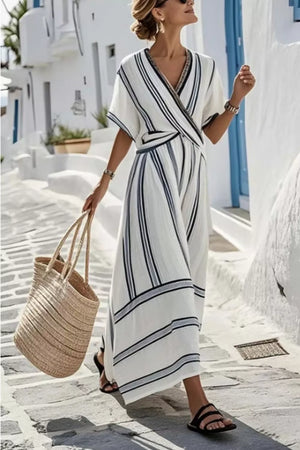 Chic striped wrap maxi dress in white with dark navy stripes, V-neck, short sleeves, and flowing skirt.
