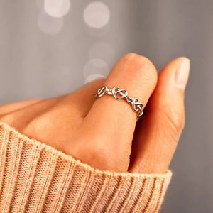Sterling silver ring with intertwined heart motif, delicate and classic design.