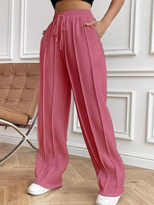 Deep Rose pleated wide-leg lounge trousers with drawstring waist and pockets.