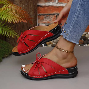 Deep Red leather slides with cutout details and bow accent.