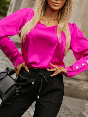 Hot Pink blouson sleeve V-neck top with button cuffs, styled with black pants.