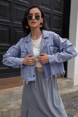 Light wash denim cropped trucker jacket with raw hem and button front.