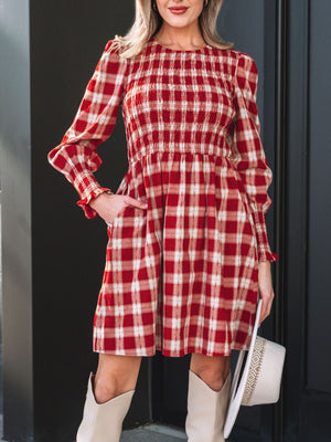 Red plaid cotton mini dress with smocked bodice, puff sleeves, and ruffled cuffs.