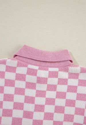 Pink checkerboard knit polo sweater with ribbed collar.