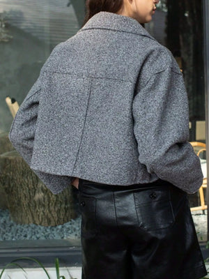 Gray cropped zip-up jacket with collar and pockets, textured fabric.