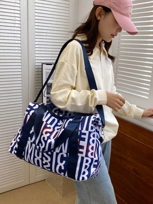 Chic travel bag with versatile straps in dark blue with white and red letter print