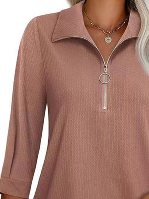 Textured zip-front polo top in dusty pink with a ring zipper pull.