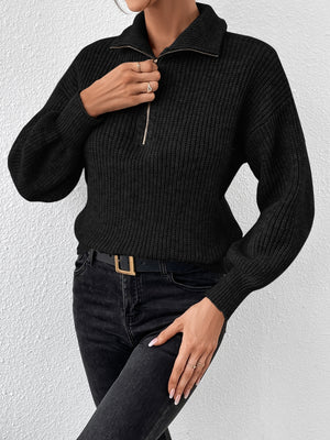 Black ribbed zip-up sweater with a collared neckline and balloon sleeves.