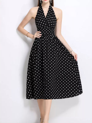 Black polka dot halter midi dress with a flared skirt.