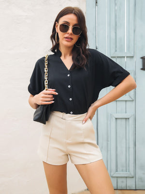 Black short sleeve blouse with notch neckline and button front, cuffed sleeves.