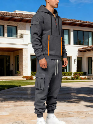 Men's dark gray half-zip hoodie and cargo sweatpants set with orange accents.