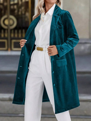 Deep teal velvet longline trench coat with lapel collar and buttoned front.