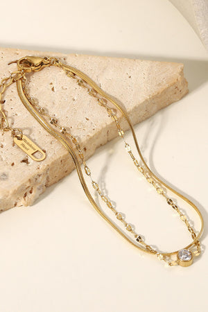 Gold double-strand bracelet with pavé charm and cubic zirconia detail