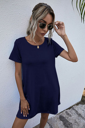 Relaxed pocketed tee dress in dark blue with short sleeves and a round neckline.