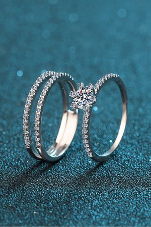 Silver ring trio with clear stones and a central starburst design.