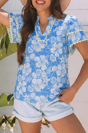 Tropical floral v-neck frill blouse in blue and white polyester with yellow trim.
