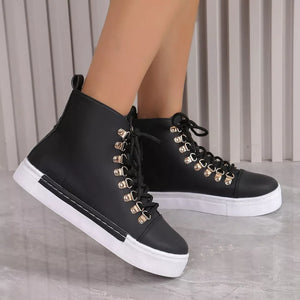 Black lace-up platform sneakers with gold D-ring eyelets and white soles.