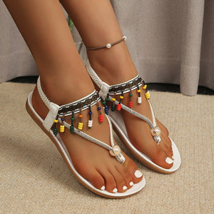 White bohemian beaded ankle strap sandals with colorful beads and pearl detail.
