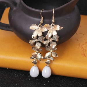 Gold cascading flower drop earrings with white pearl accents