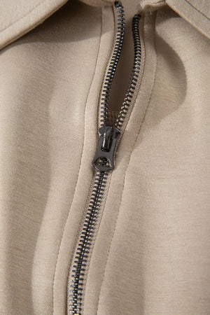 Chic collared zip front romper in beige with cap sleeves and pockets.