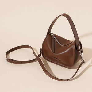Caramel leather crossbody bag with adjustable strap and silver hardware.