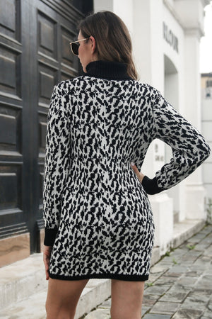 Black houndstooth knit turtleneck mini dress with long sleeves.