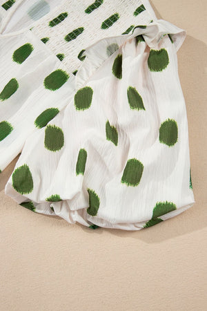 White blouse with green textured polka dots and smocked yoke.