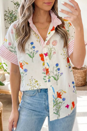 Charming floral print button-down shirt with ruffled collar and pink striped cuffs.