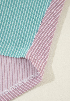 Waffle knit colorblock shirt in dusty pink and teal with vertical stripes and a button-up front.