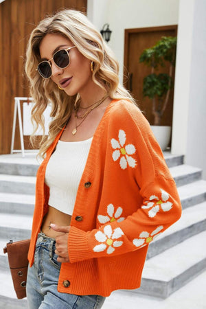 Orange knit cardigan with white daisy embroidery, button front, and crew neck.