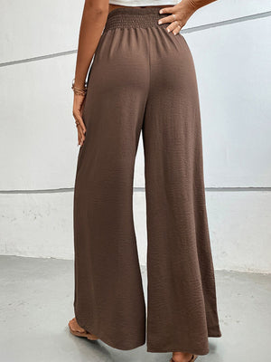 Brown textured smocked waist palazzo maternity pants with wide legs.