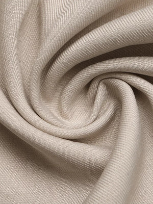 Elegant wide-leg romper fabric detail in beige with subtle texture and draped folds.