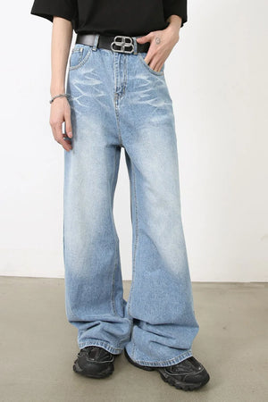 Oversized medium wash denim jeans with distressed details and a wide leg.