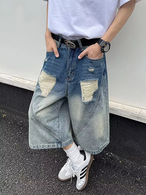 Men's distressed wide-leg denim shorts in light blue wash with ripped details.