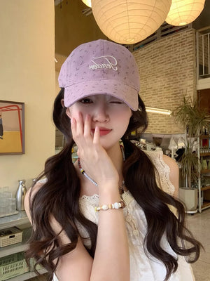 Purple embroidered floral cotton baseball cap with white script detail.