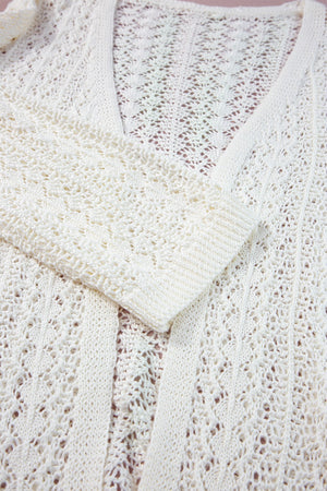 White open-knit crochet sleeve cardigan with intricate openwork pattern and ribbed cuffs.