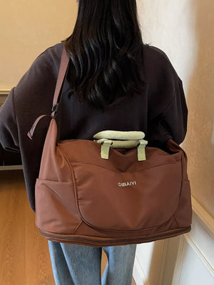 Spacious brown Oxford cloth travel duffel bag with side pockets and top handles.