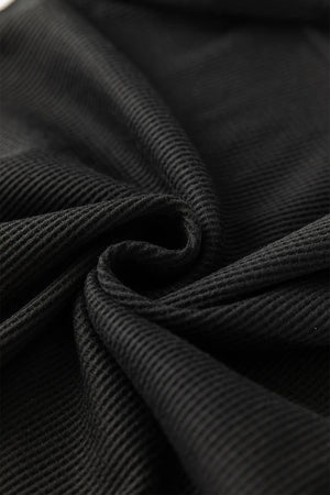 Black ribbed knit fabric detail, showing texture and drape