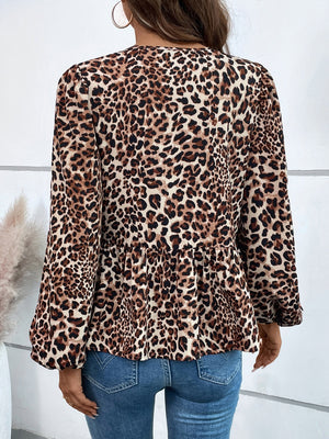 Leopard print peplum blouse with long sleeves and a ruffled hem.