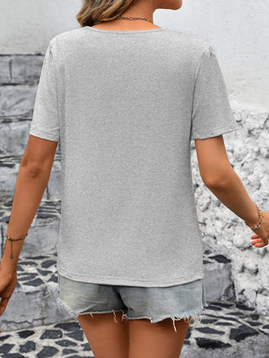 Light gray jersey top with pleated shoulder detail and short sleeves.