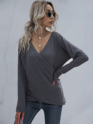 Dark gray waffle knit crossover blouse with V-neck and long sleeves.