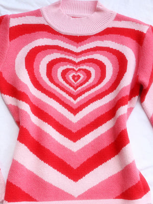 Pink mock neck sweater with concentric heart stripes and ribbed neckline.
