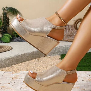 Gold wedge sandals with peep toe and elastic ankle strap, featuring a high platform sole.