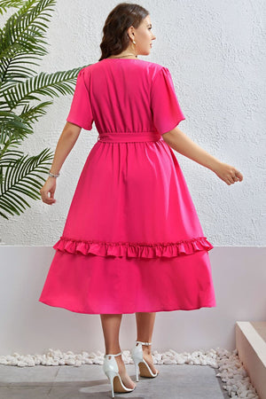 Hot pink wrap-front midi dress with tiered ruffled hem and belted waist.