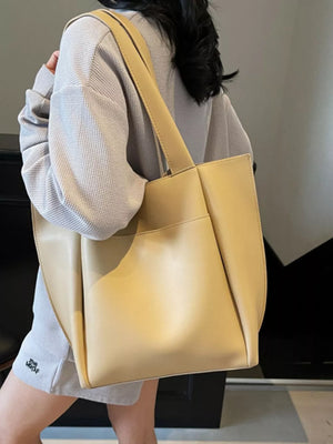 Khaki pu leather tote bag with a minimalist design and shoulder strap.
