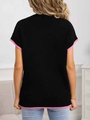 Black knit top with pink ribbed crew neck, cuffs, and hem