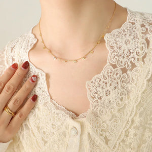 Gold necklace with dangling eye charms on a delicate chain