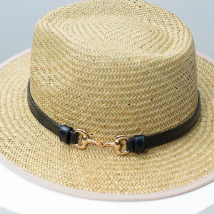 Woven straw fedora hat with black decorative band and gold buckle detail.