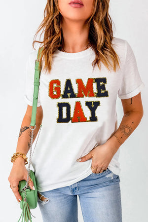 White graphic tee with sequin-trimmed GAME DAY text and rolled sleeves.